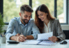 Couple souriant examinant des documents de location voiture