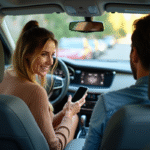 Prime de covoiturage : comment obtenir cette incitation financière ? Femme souriante montrant son smartphone dans la voiture