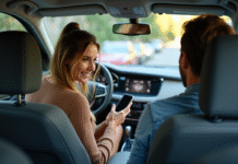 Prime de covoiturage : comment obtenir cette incitation financière ? Femme souriante montrant son smartphone dans la voiture